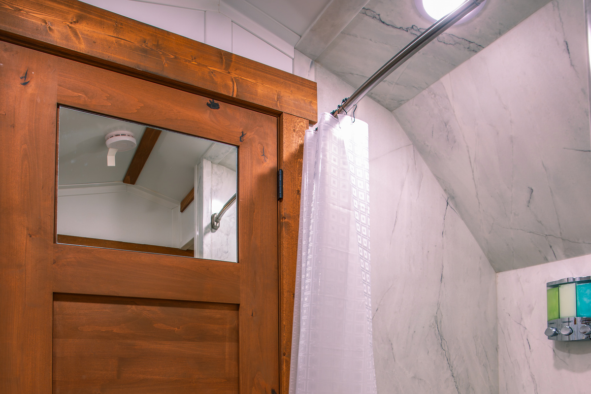 Private shower with clean modern finishes inside the wagon bathroom.