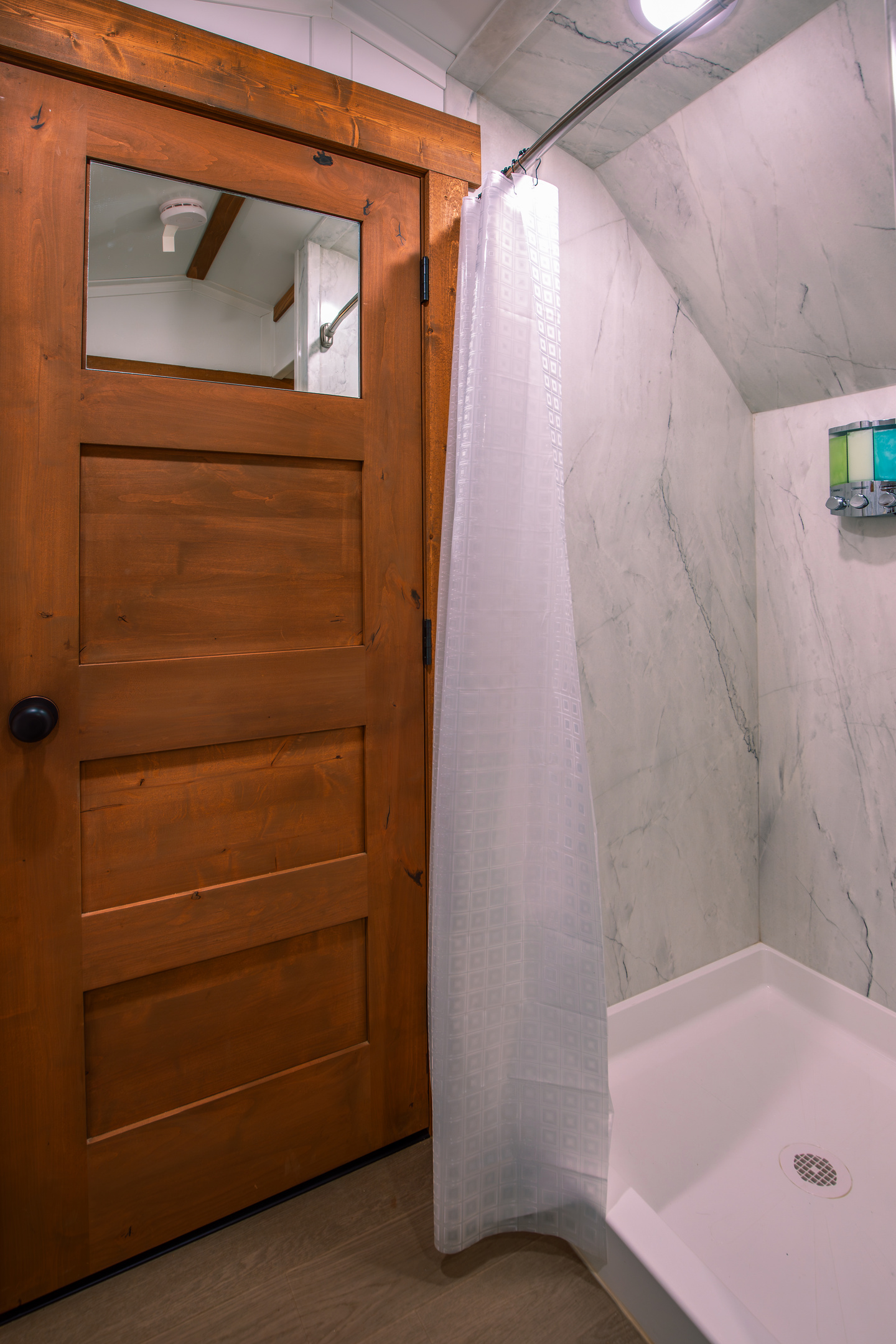 Private shower with clean modern finishes inside the wagon bathroom.