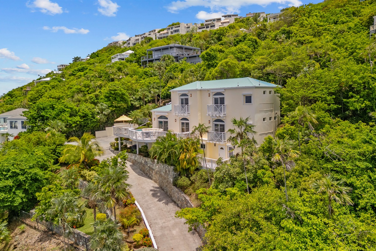 Charming island villa exterior with tropical plants and free parking. A beautiful welcome, every time.
