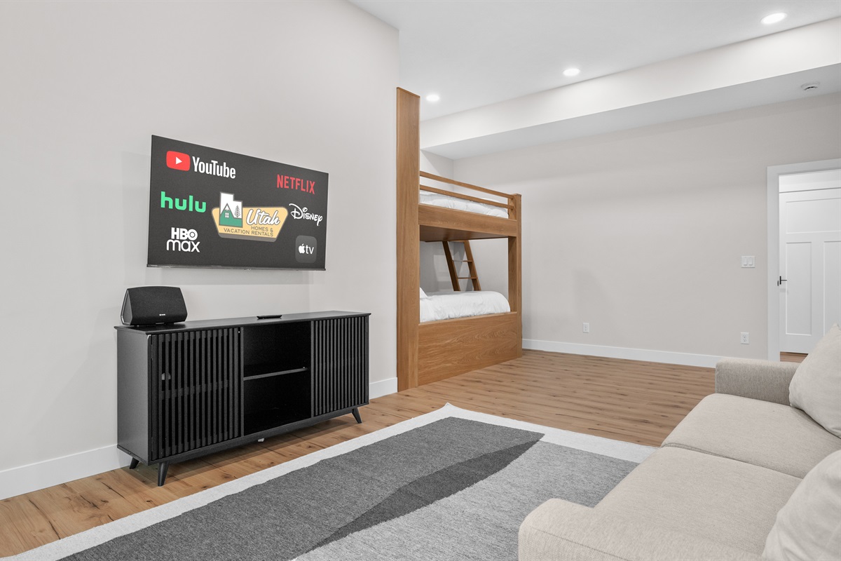 Spacious lower-level bunk room with entertainment area for the ultimate hangout space.