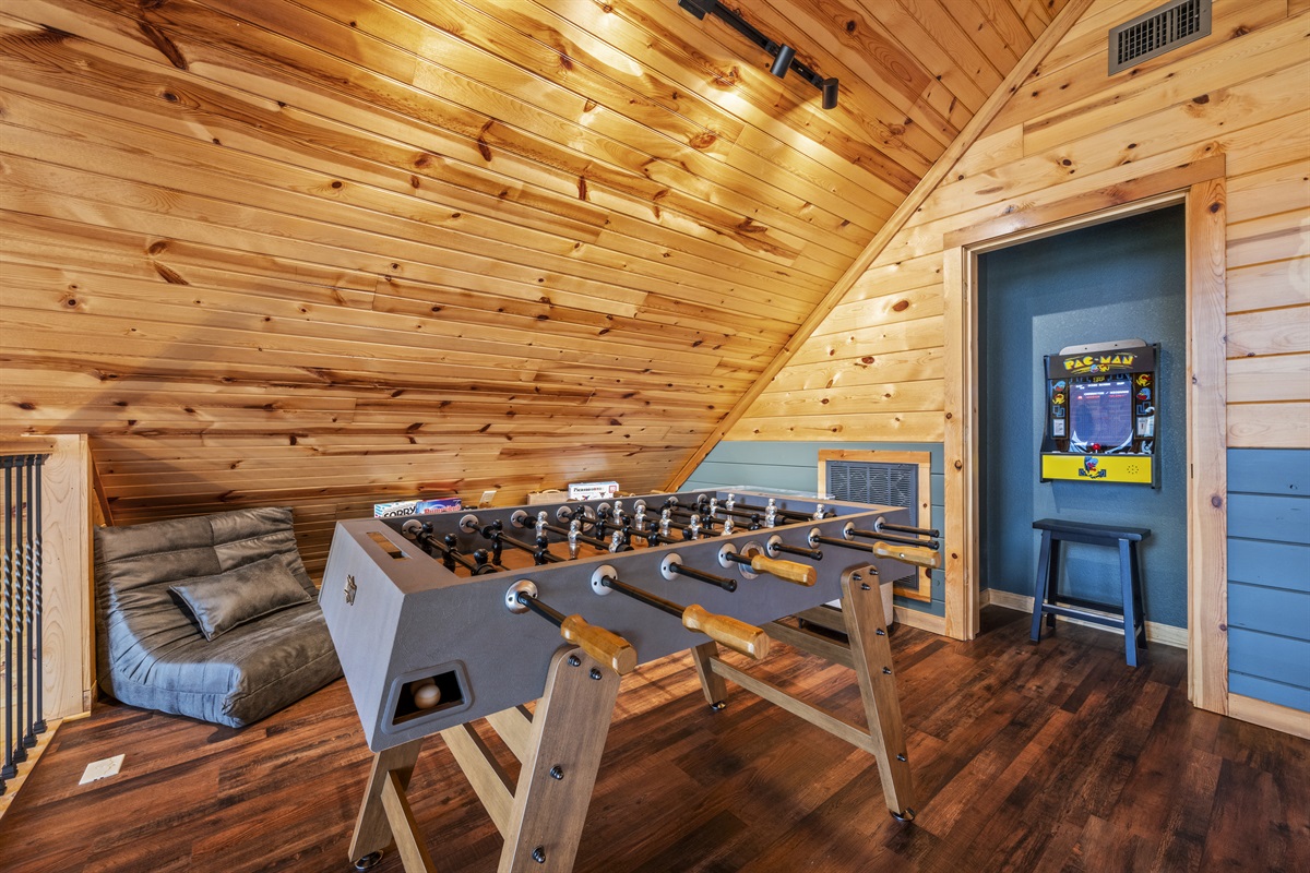 2nd floor: Step into the game room at Signature Stay, featuring arcade games, foosball, and a variety of board and card games for endless family fun