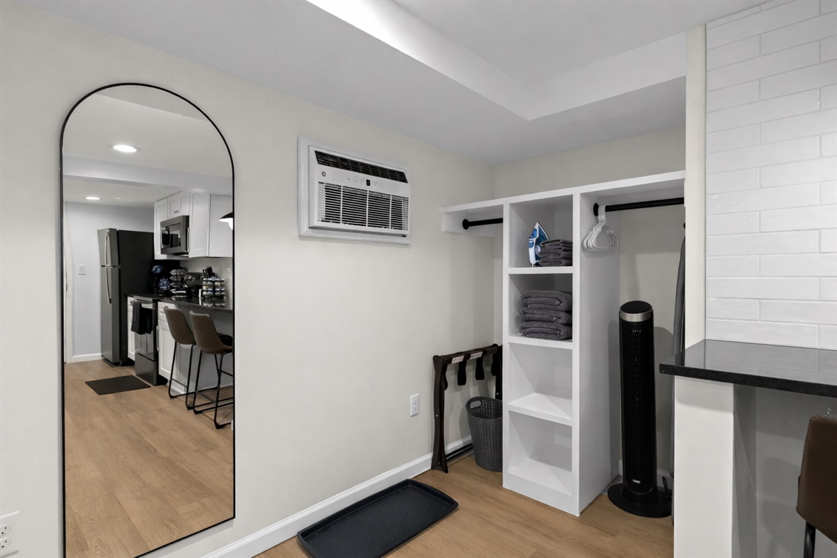 Smart storage and prep area with open shelving, hanging space, and a full-length mirror—perfect for staying organized and settling in with ease.