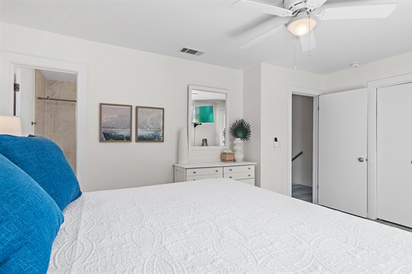 Cozy Coastal Chic Master Bedroom: Unwind in the master bedroom with a luxurious king-sized bed, private bath, and a balcony offering serene views.