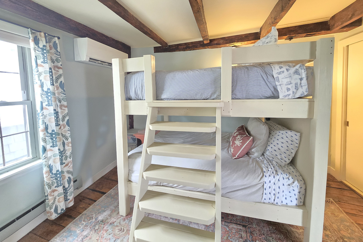 Queen size beds in bunk room with sturdy ladder for upper bunk and AC