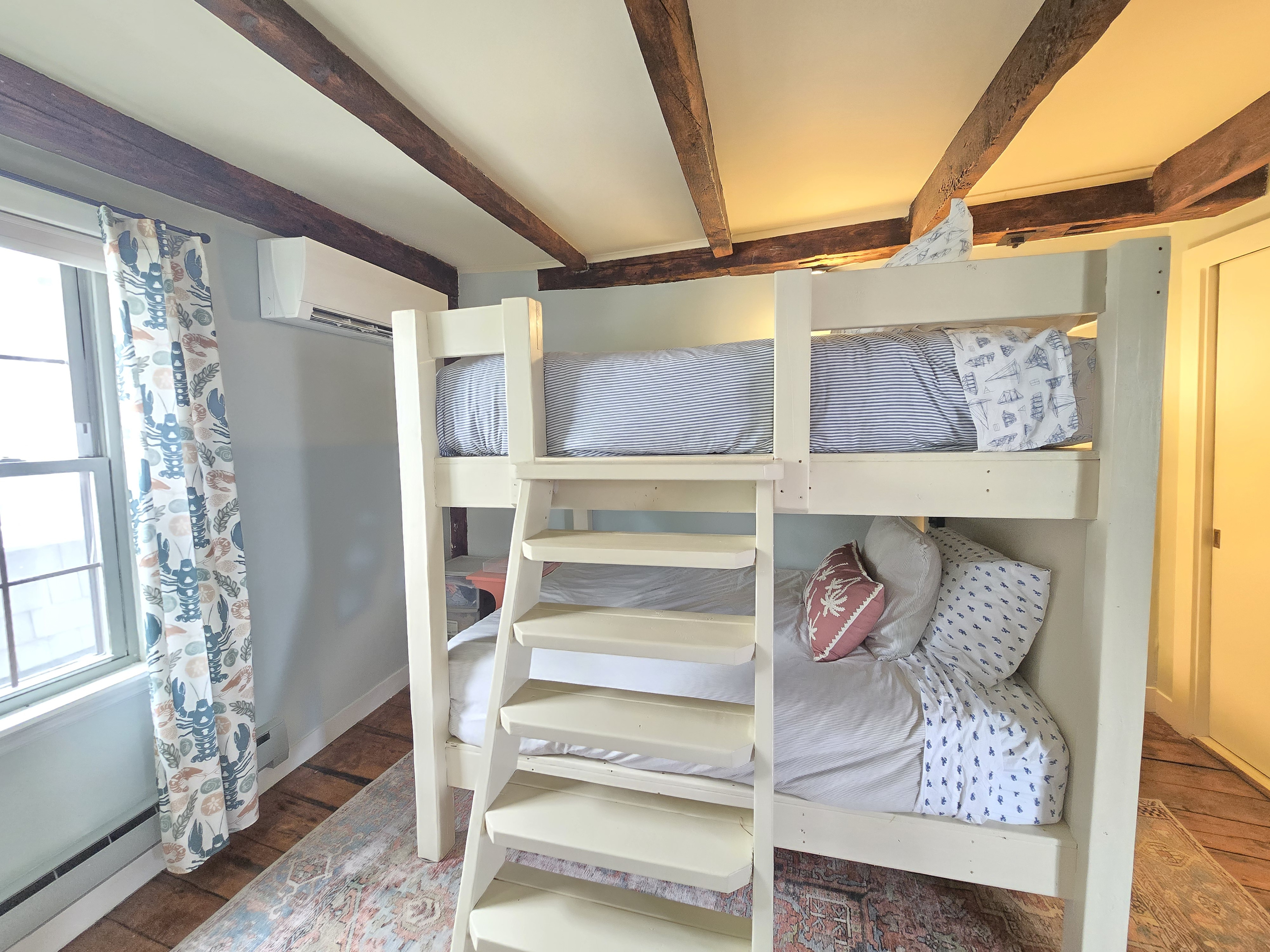 Queen size beds in bunk room with sturdy ladder for upper bunk and AC