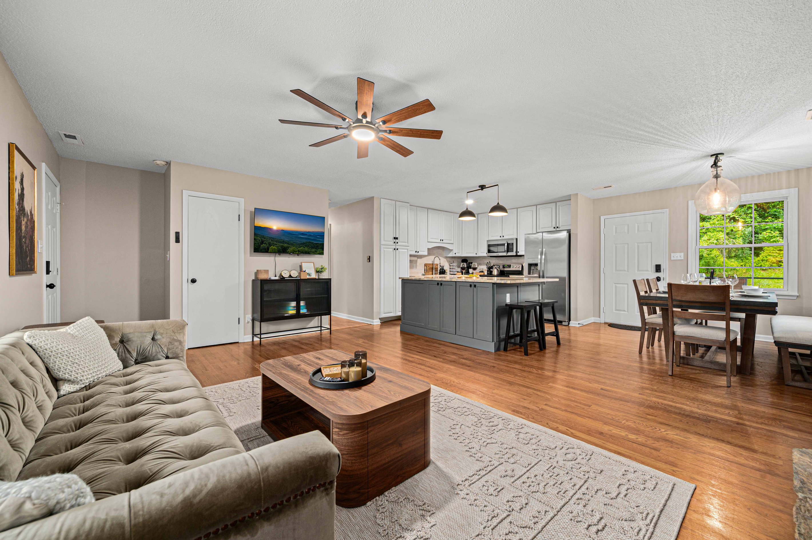 Living Room & Kitchen: Bright, open space with modern decor and a view of nature awaits you!