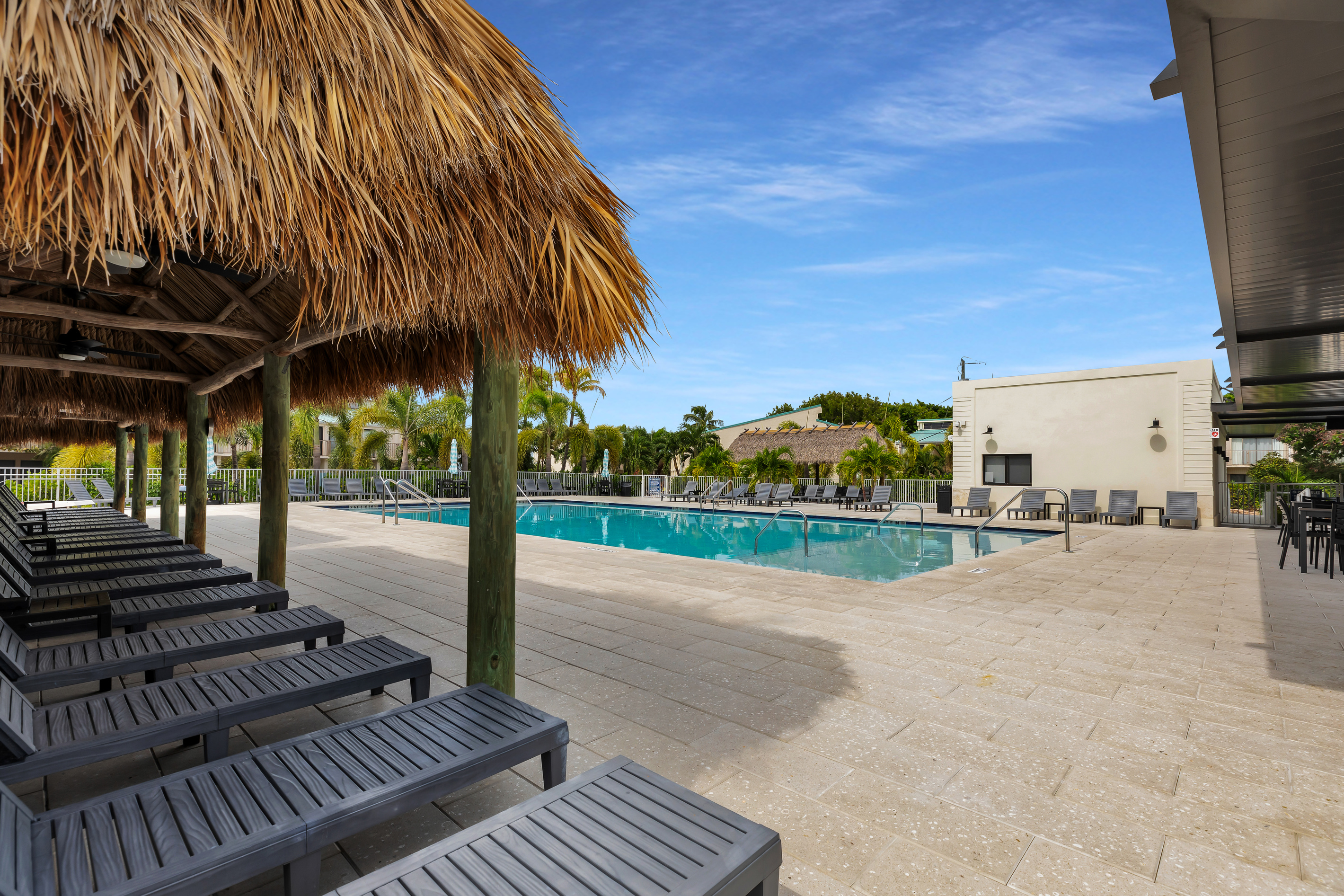 Brand new sparkling pool with tiki huts for shade