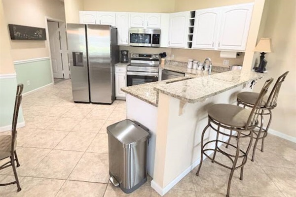 Updated kitchen with stainless steel appliances, granite countertops, breakfast bar seating, and plenty of cabinet space.