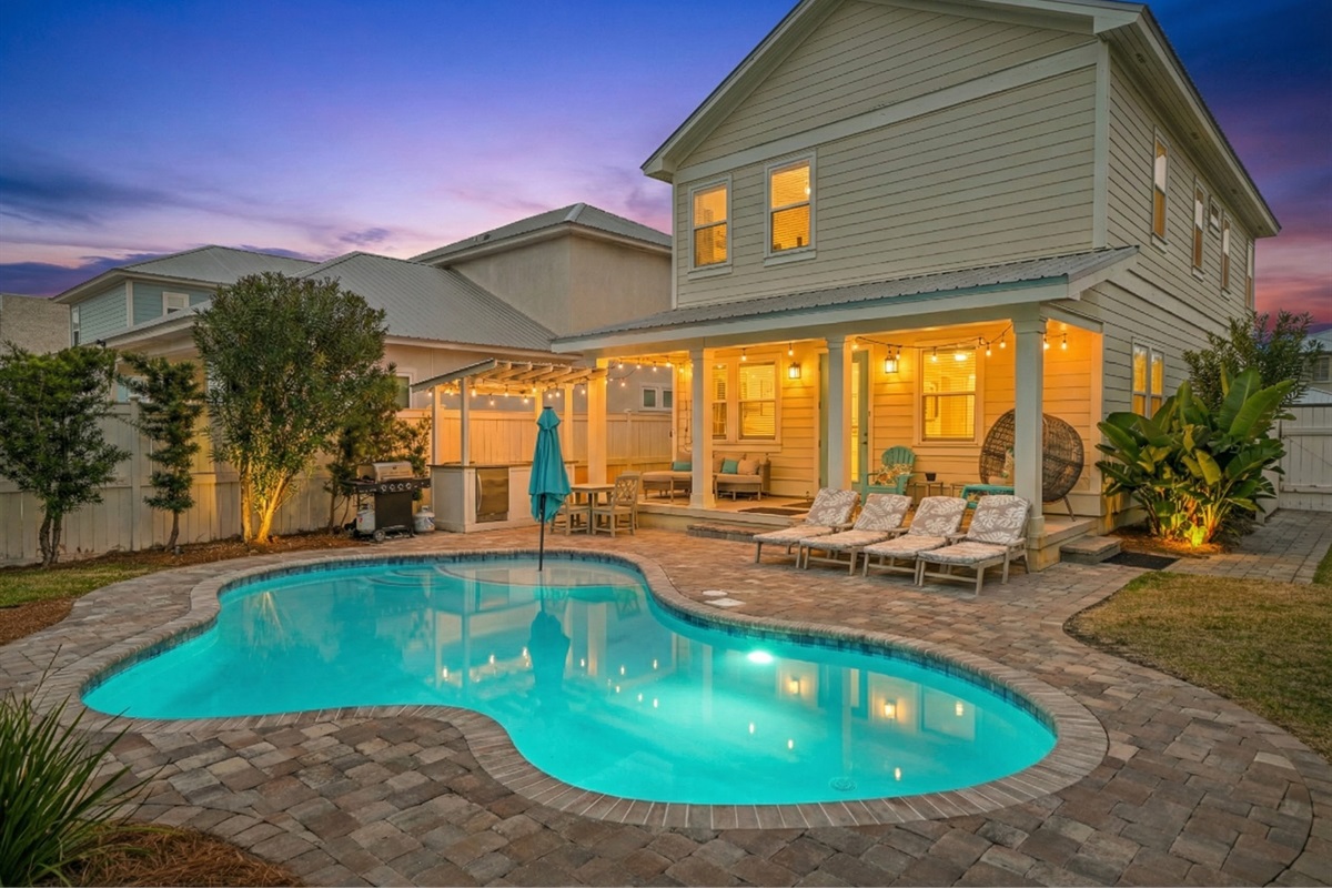 Heated pool, patio, and backyard at dusk—perfect for evening swims and outdoor entertaining.
