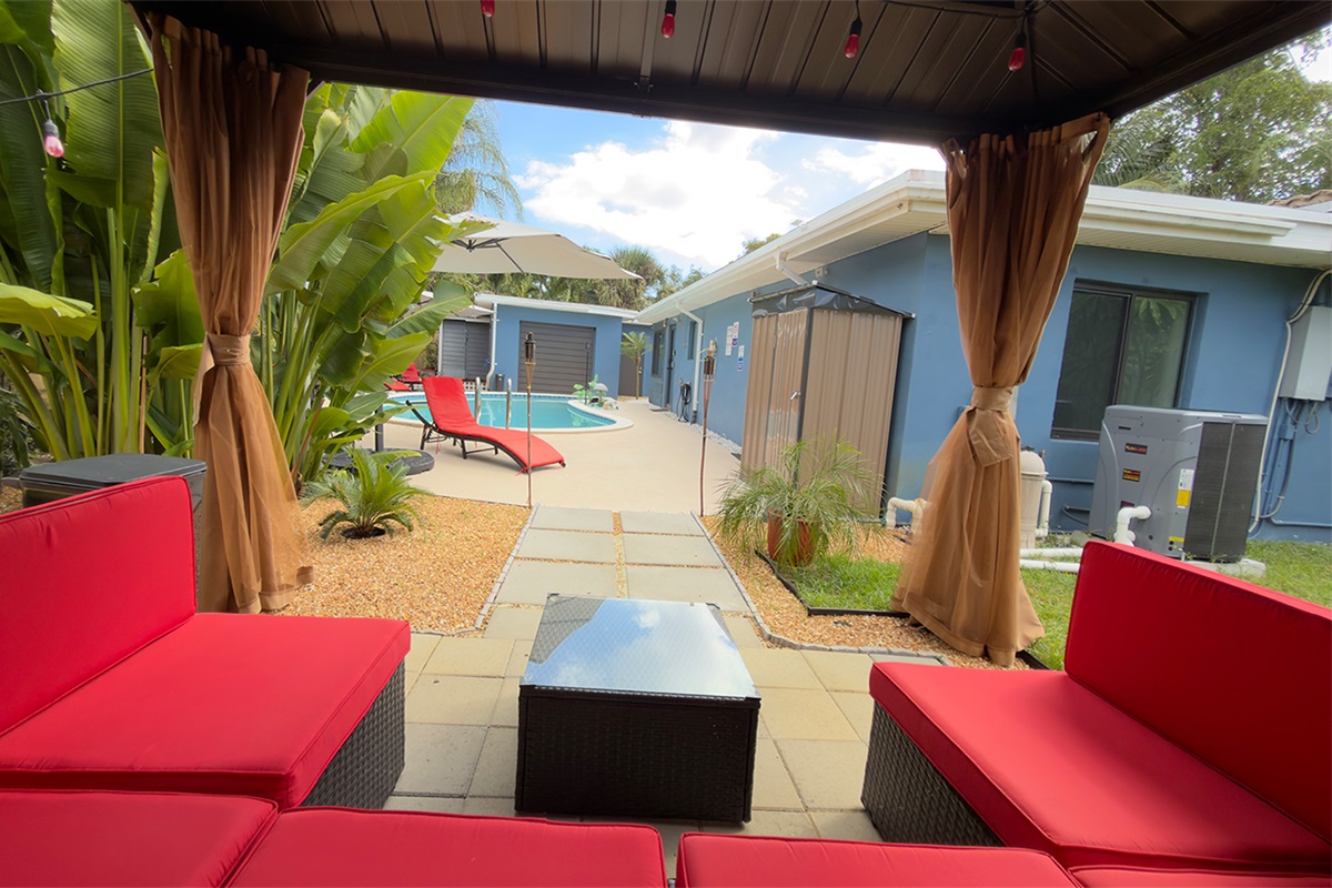Outdoor lounge area at Garden of Manors, featuring comfortable seating and direct views of the pool.