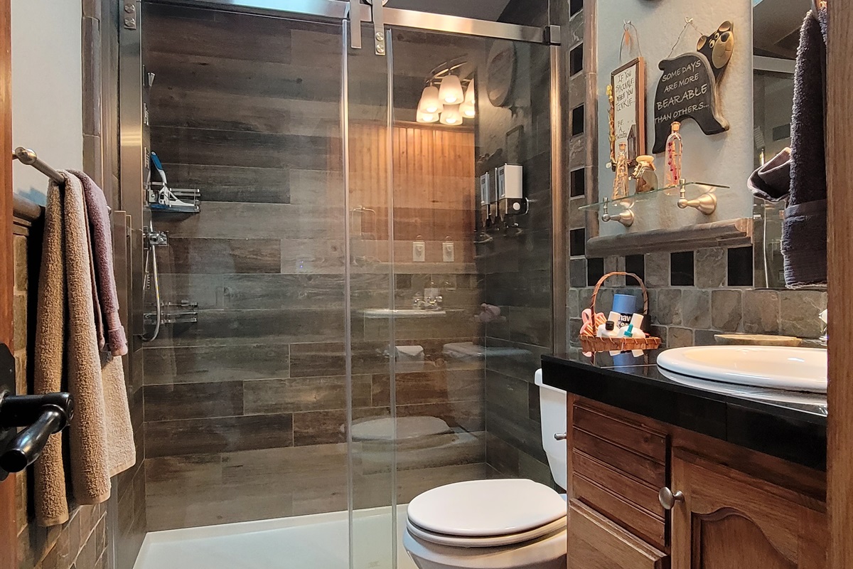 Waterfall shower in guest bathroom next to King guest room and bunk bed room