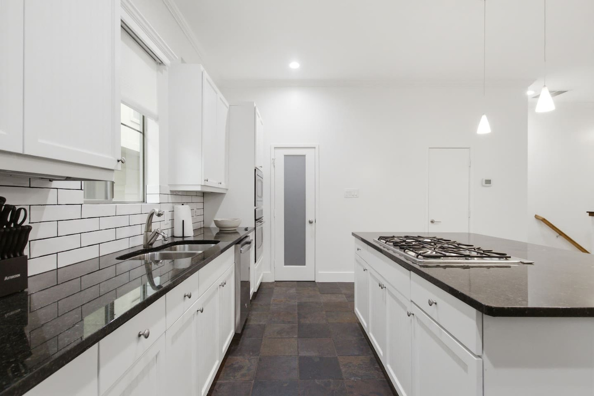Generous counter space, white shaker cabinetry, and a classic subway tile backsplash. The kitchen is fully stocked and ready from the moment you arrive, no grocery run required.
