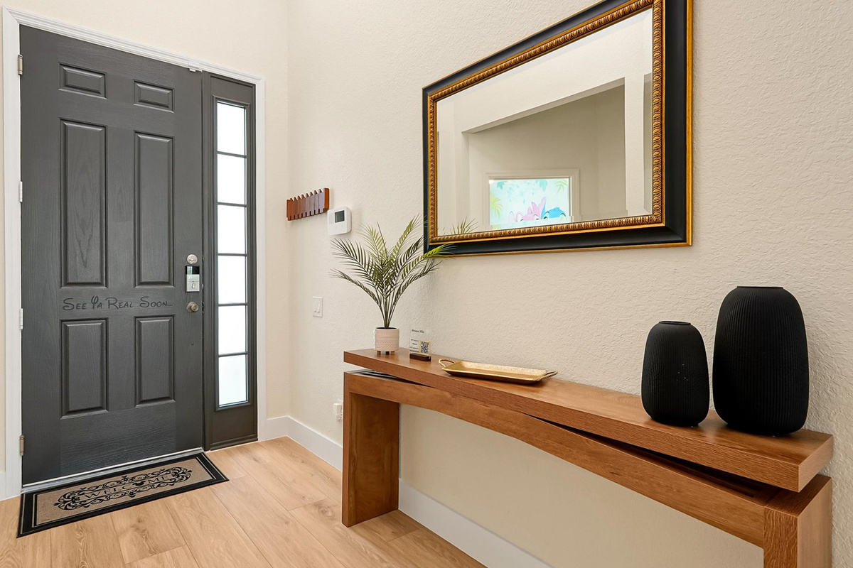 Front Entry: Welcoming entrance to Motunui Villa with a modern wood console, decorative mirror and convenient key hooks.