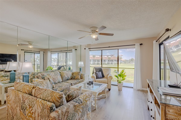 Comfy seating in the living area with balcony access and golf course view