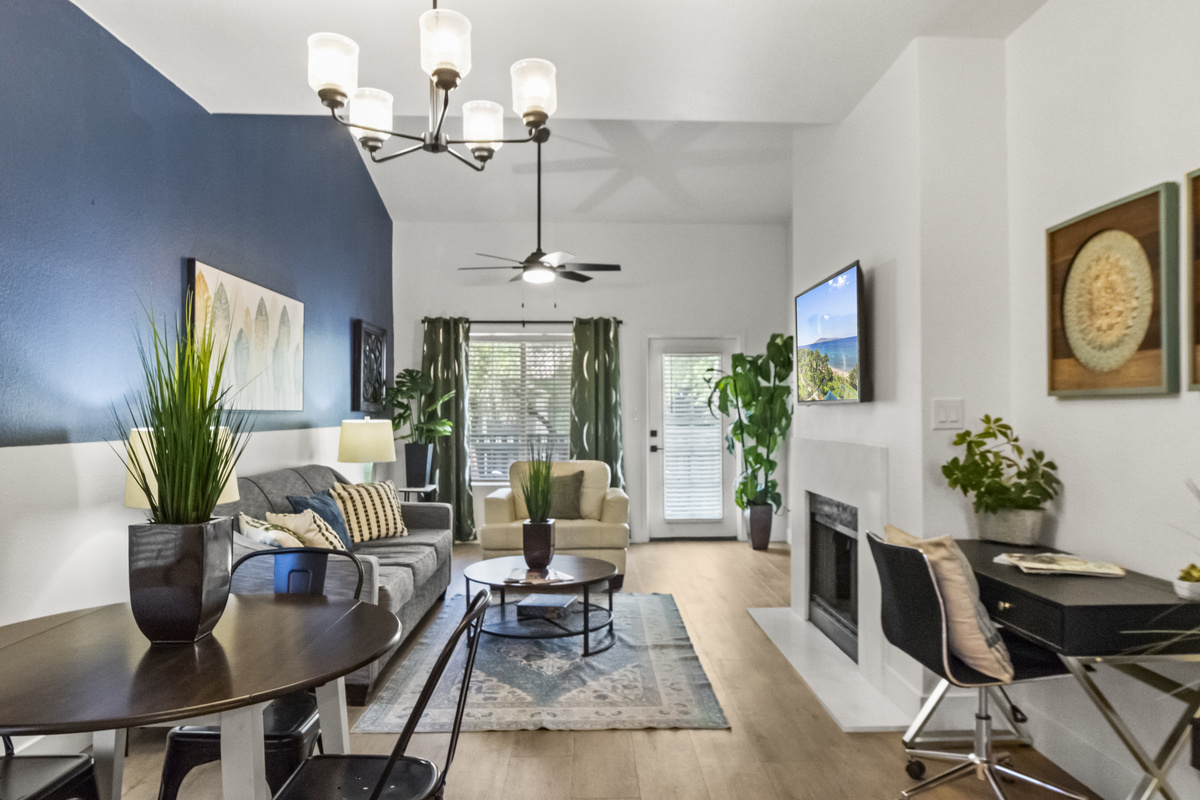 Spacious living room with a Roku smart TV, work desk, a fire place and a snug couch for added comfort. 