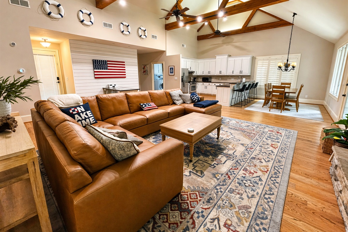 Cozy up in the spacious great room with soaring ceilings, a stone fireplace, and plenty of room for everyone to relax after a day on Lake Lanier.