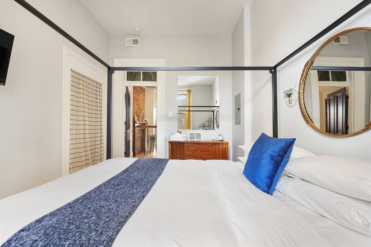 Cozy queen-sized bed with a unique frame and a TV for laid-back movie nights.