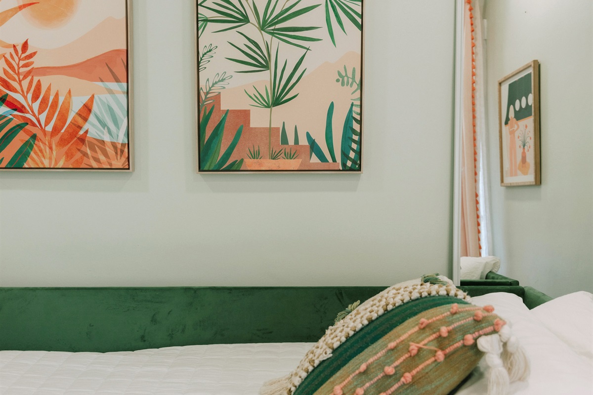 The third bedroom has a daybed and a pullout bed, garnished with colorful art throughout.