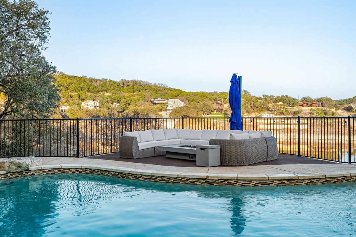 Poolside sun deck with plush seating overlooking the water.