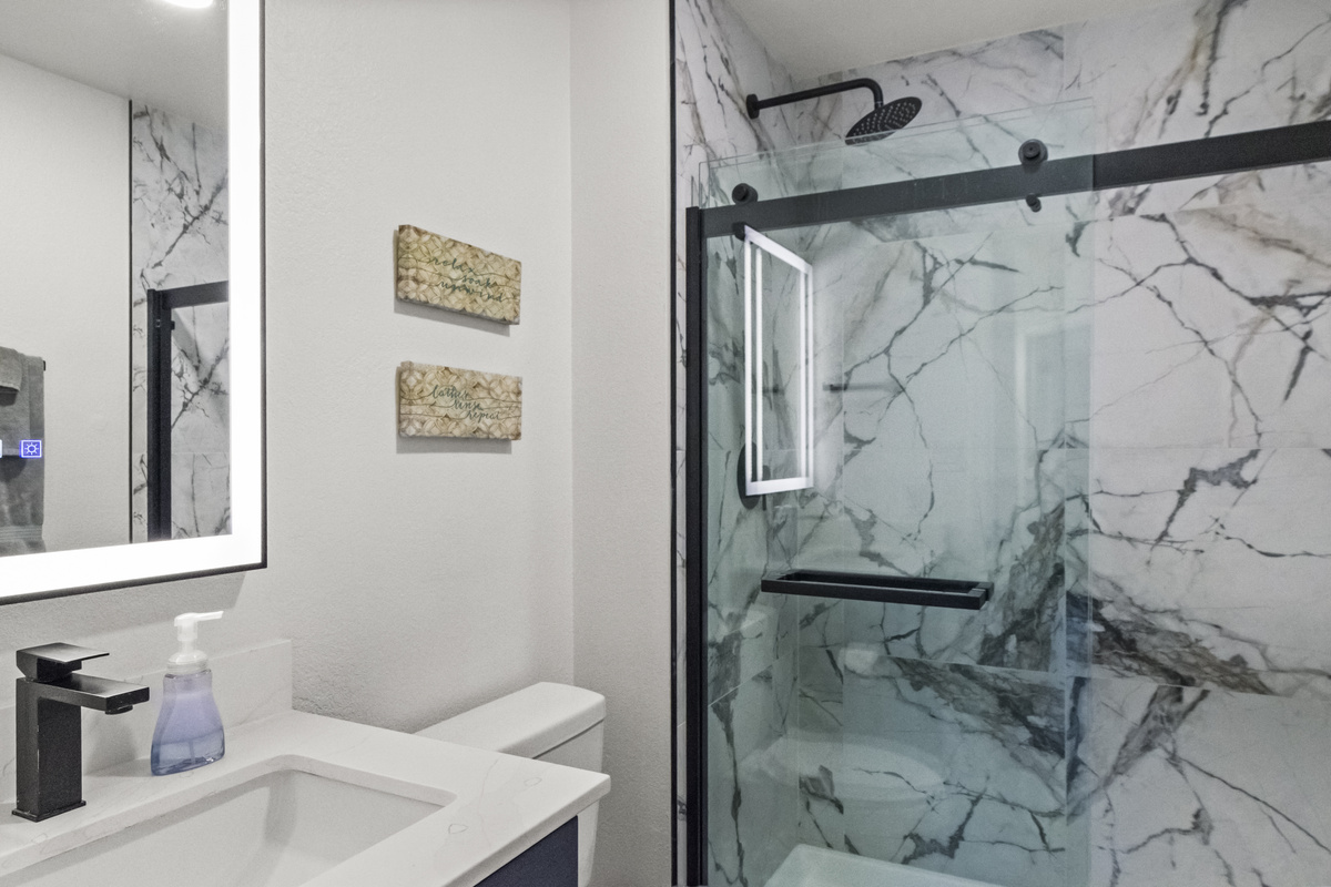Clean and spacious bathroom with glass patition for the shower area. 