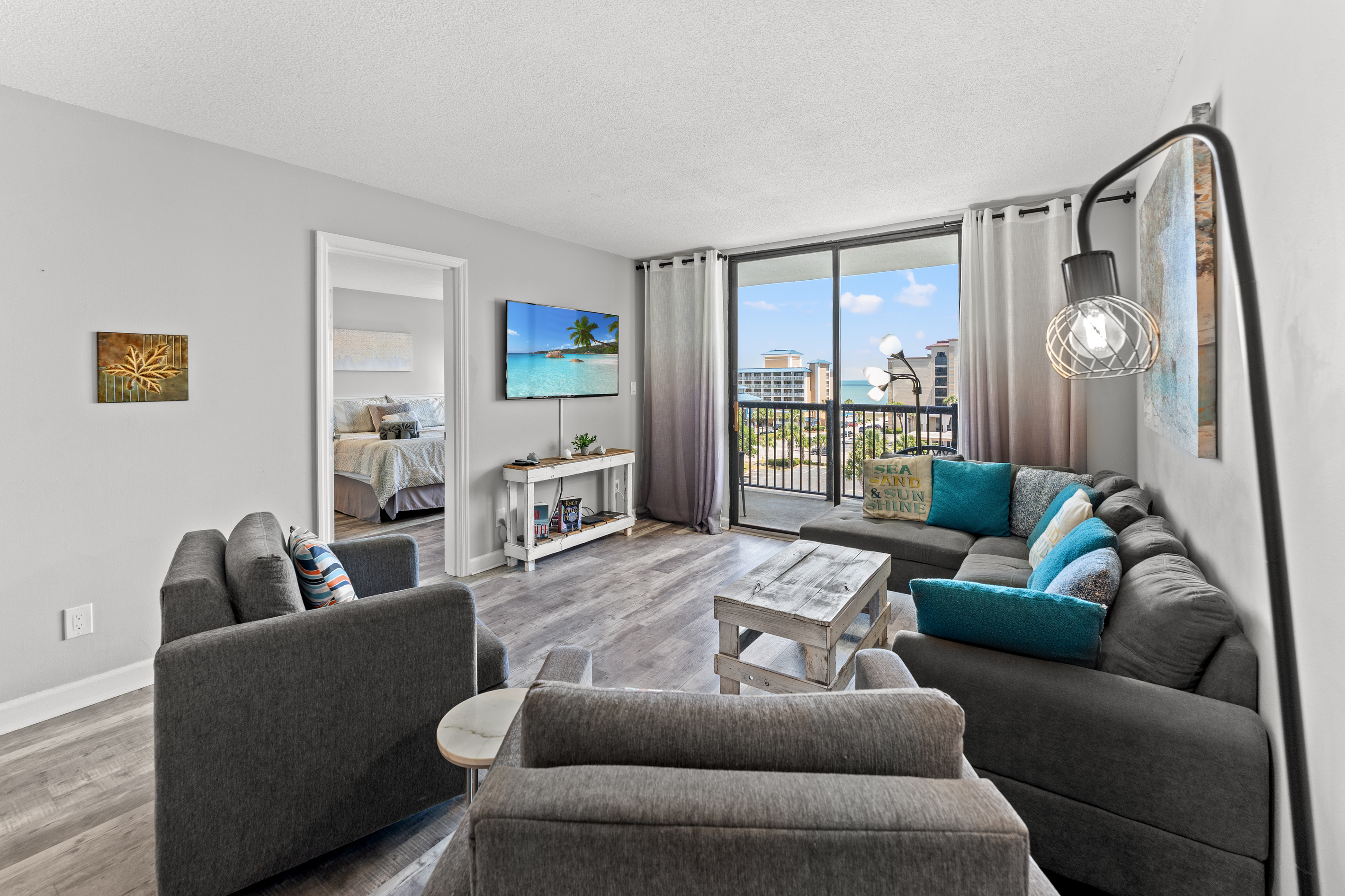Comfy living room area with large TV and balcony access