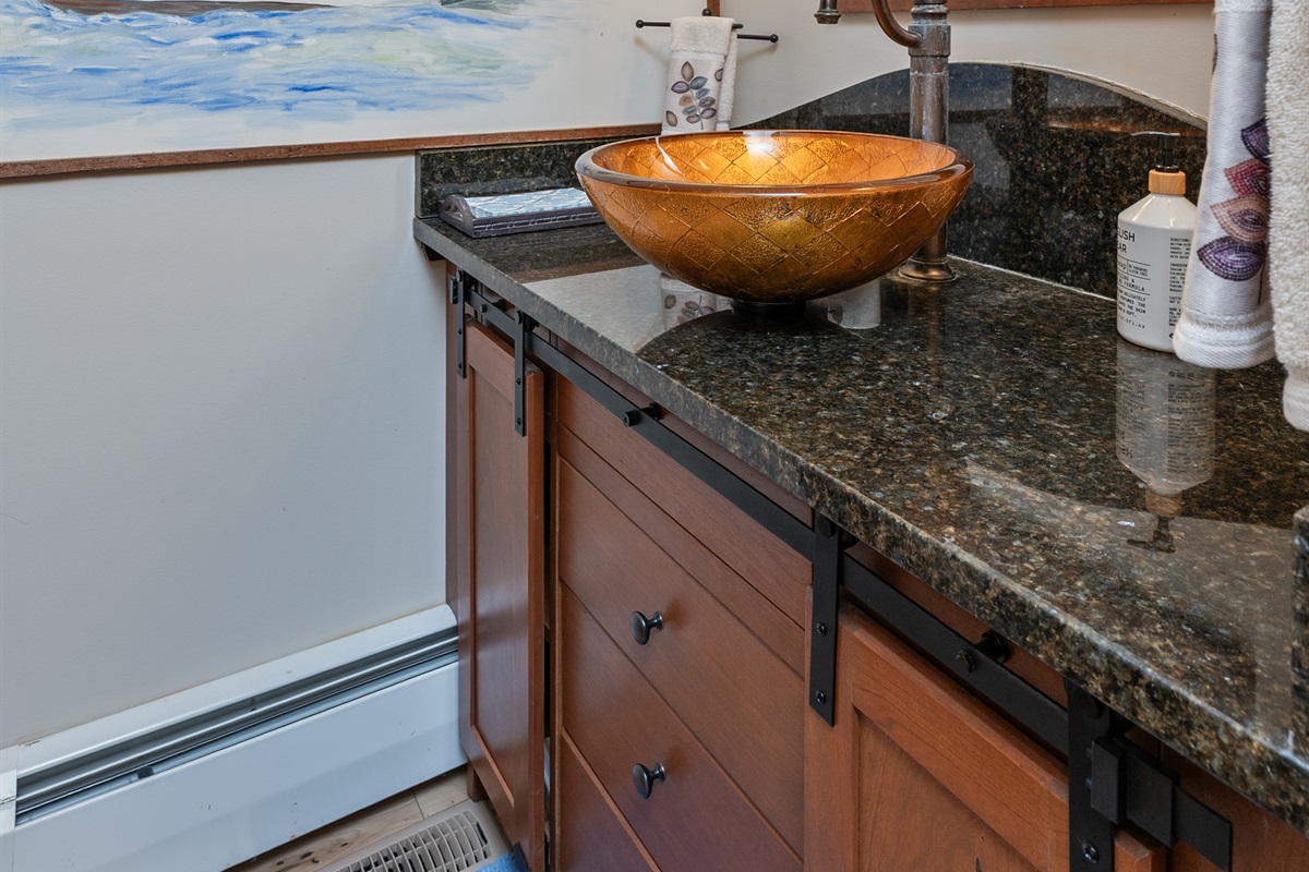 Stylish half bath with a granite vanity and modern vessel sink – perfect for guests on the go.