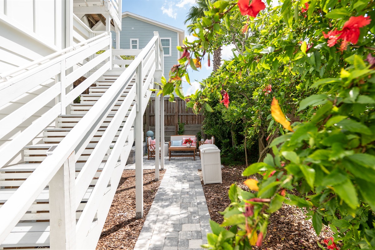 Descend the side stairs and step into your own tropical oasis! The backyard is a cozy retreat, lined with stunning Floridian vegetation and featuring a lush lime tree—perfect for relaxing and enjoying the serene surroundings.