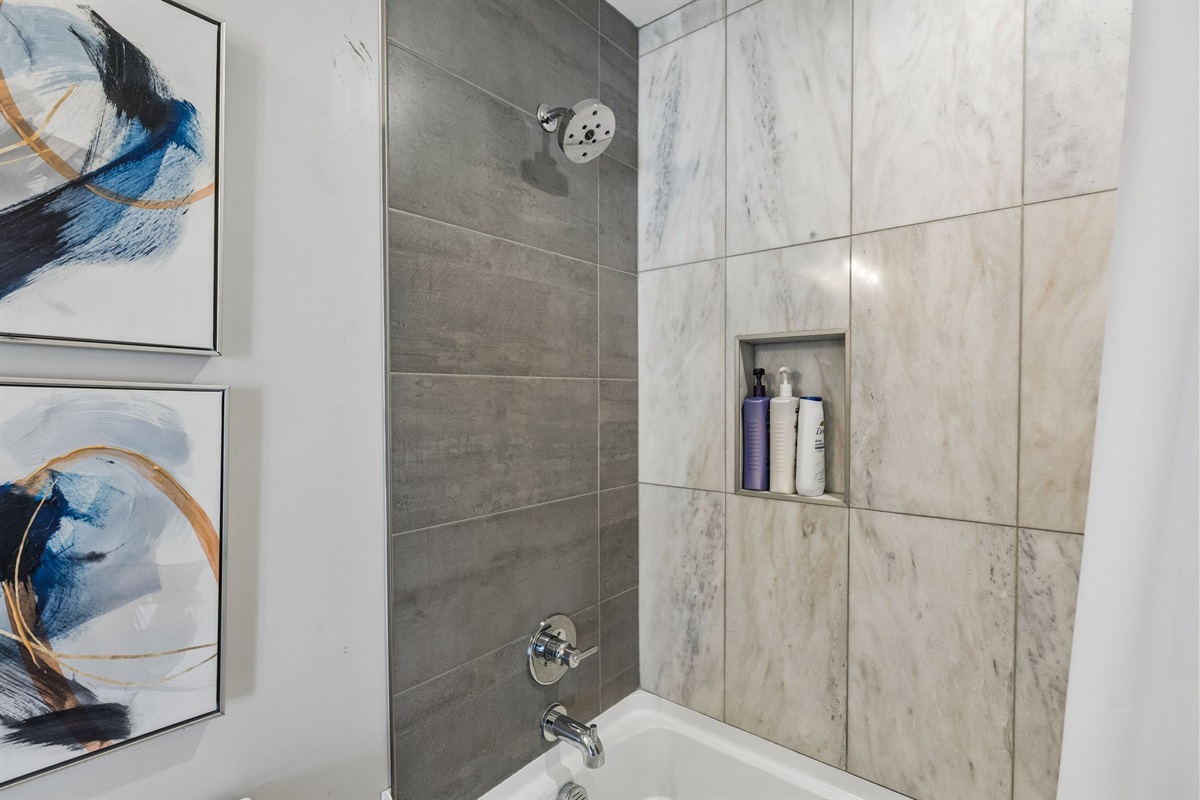 Step into the third full bathroom and you'll get the same clean finish as the rest of the house &mdash; tub-shower combo, white tile, ready for your group.