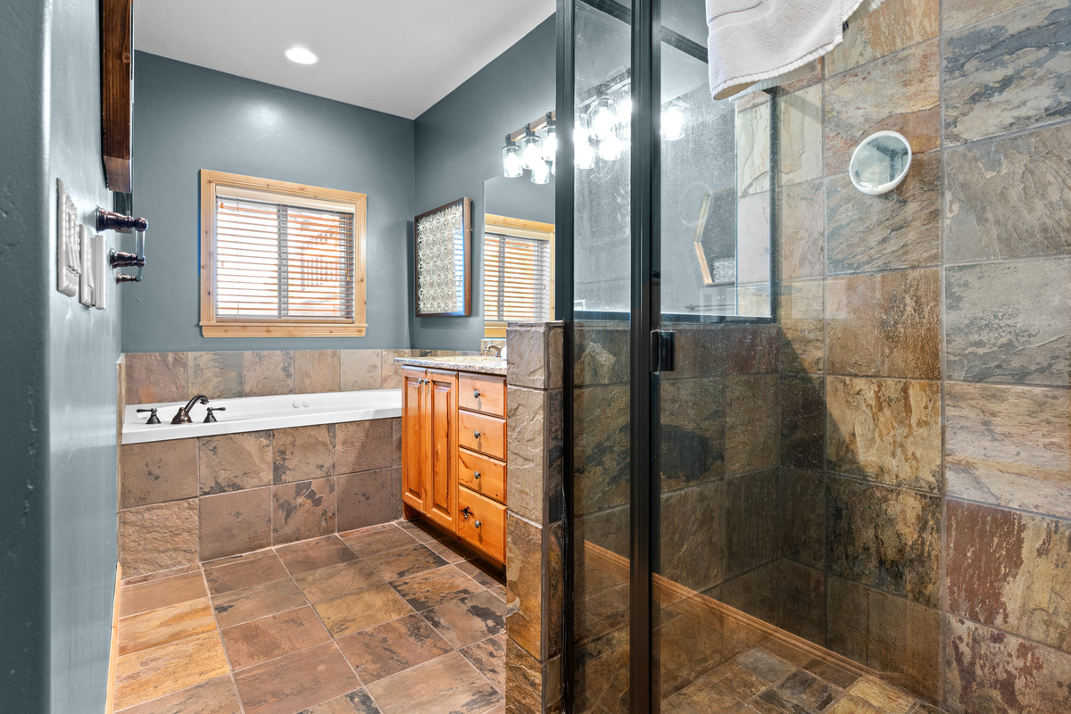 Beautiful bathroom with tiled walk-in glass shower and soaking tub.