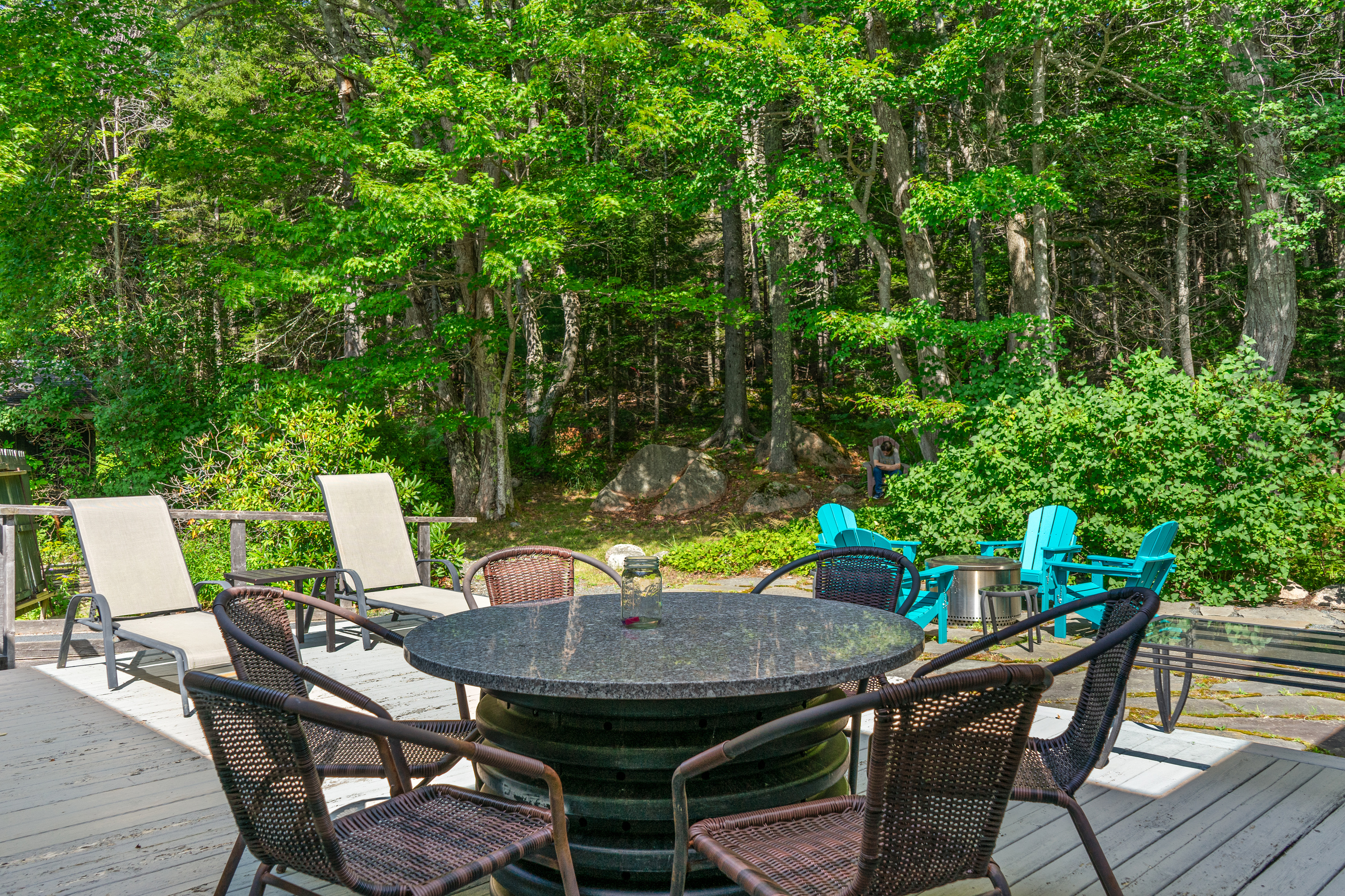 The expansive 33ft deck flows seamlessly into a custom stone fire pit area at the edge of the Acadia National Park woodlands. Equipped with a gas grill and Adirondack seating, this is the ultimate space for sunset dinners and stargazing.