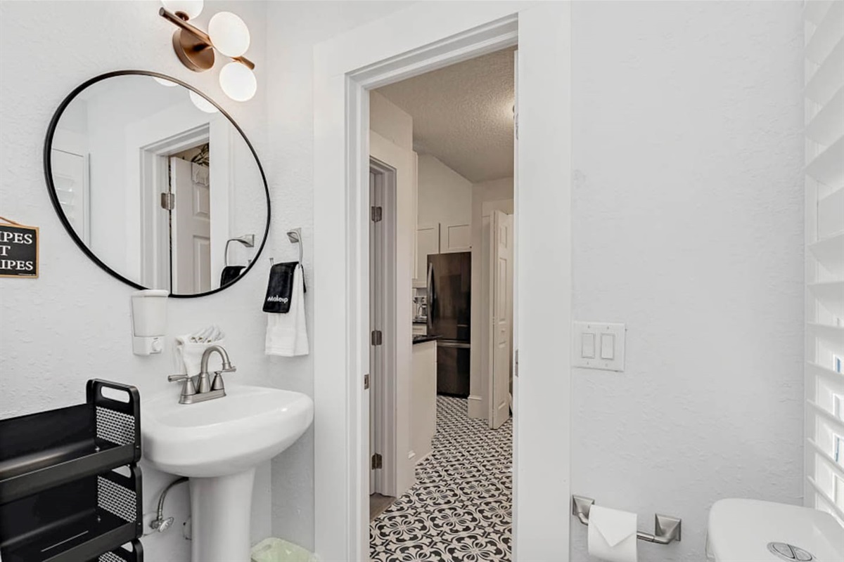 bathroom in back corner of house near kids room and back door with tub shower combination