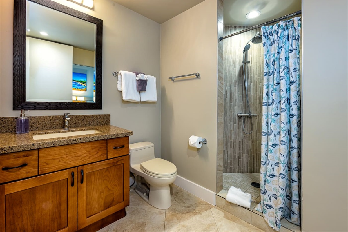 the main bathroom features a vanity and large walk-in shower with rain shower-head