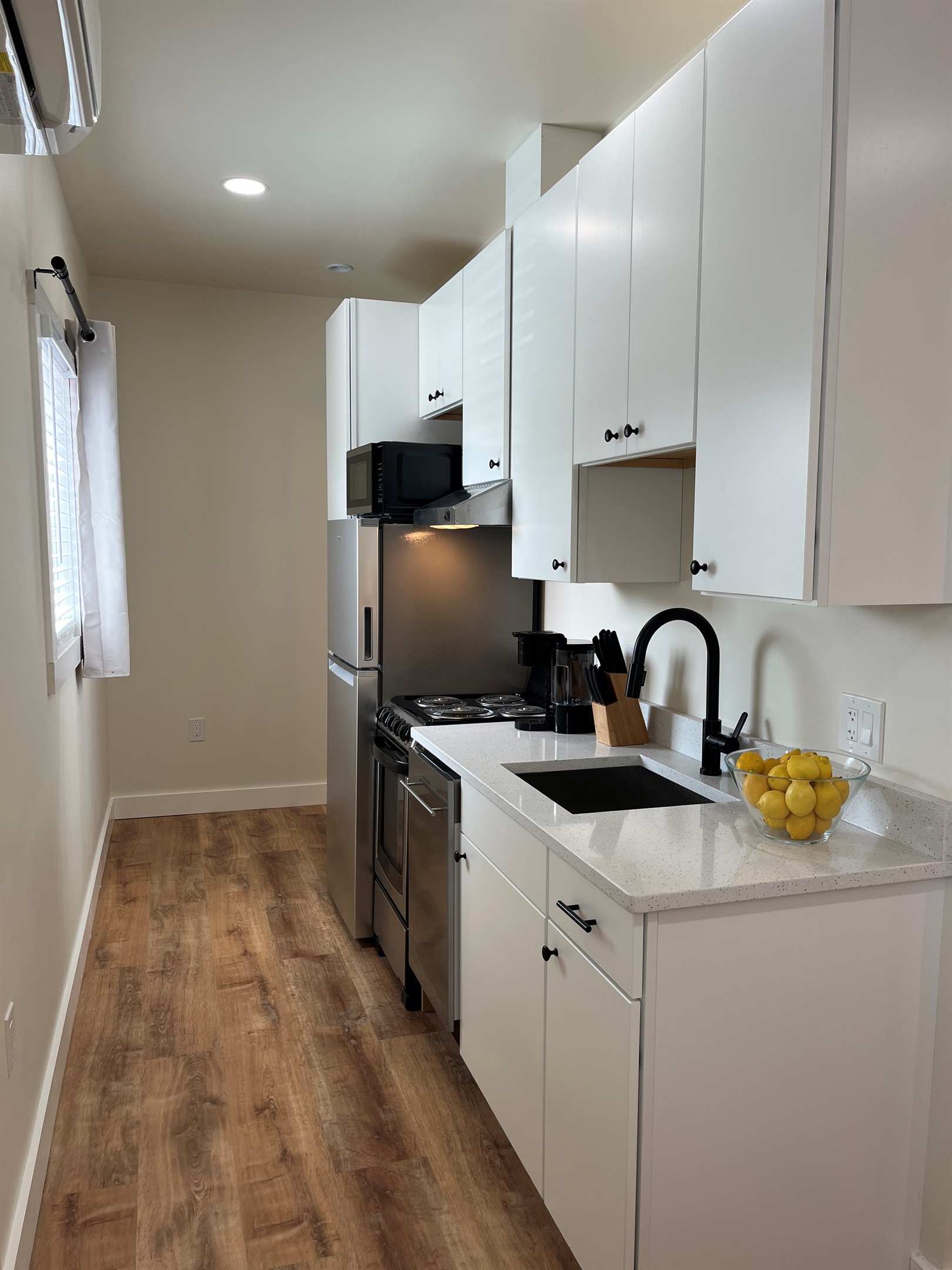 Kitchen area leading to full bathroom