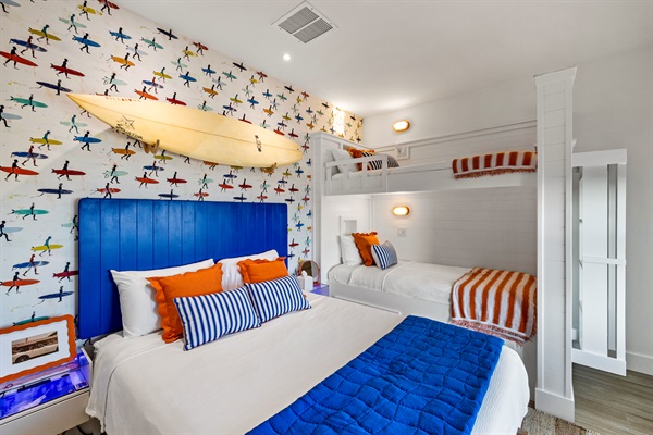 The Sunrise Surf Bedroom includes spacious bunk beds, a comfortable queen bed, beautiful views and nearby access to the second floor balcony. Guests will utilize the half bath on the main floor and shower in another guest suite.