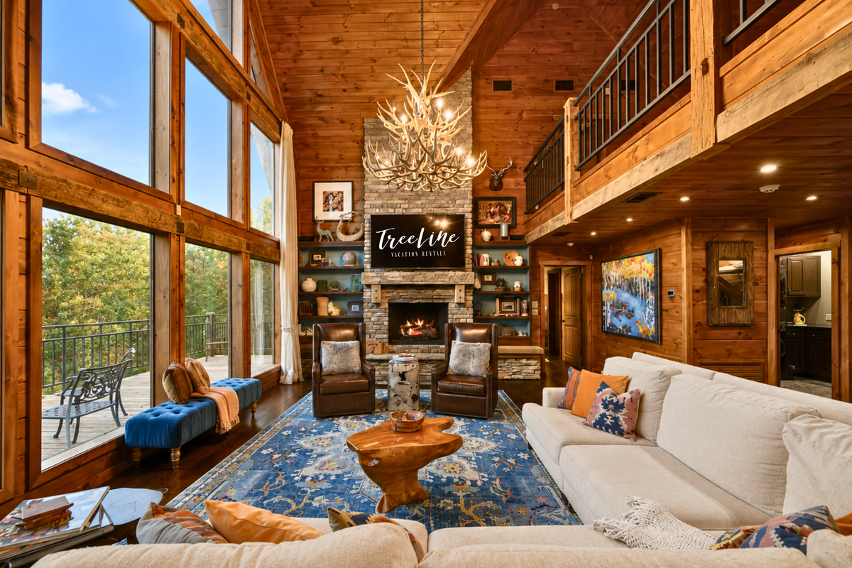 Soaring windows fill the main living area with natural light while the stone fireplace, comfortable seating, and warm wood details create an inviting place to spend time together.
