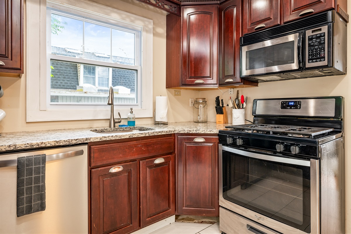 Cook with ease in a well-equipped kitchen featuring rich wood cabinetry and modern appliances 🍳☕🔪