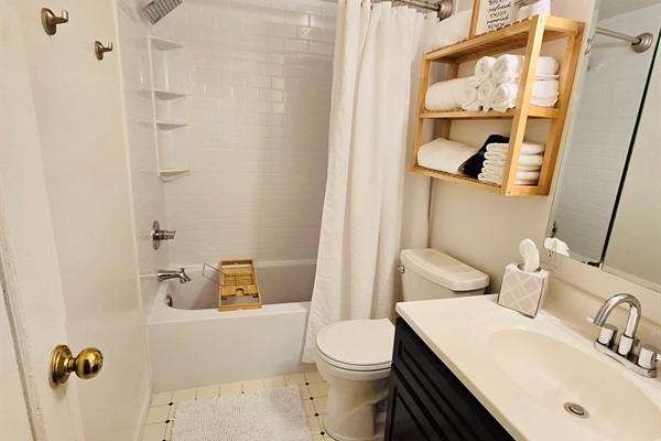 White, crisp, and spa-inspired—our bathroom features an oversized shower head, plush linens, and a bath tray ready for your book and beverage. Just add steam and serenity.