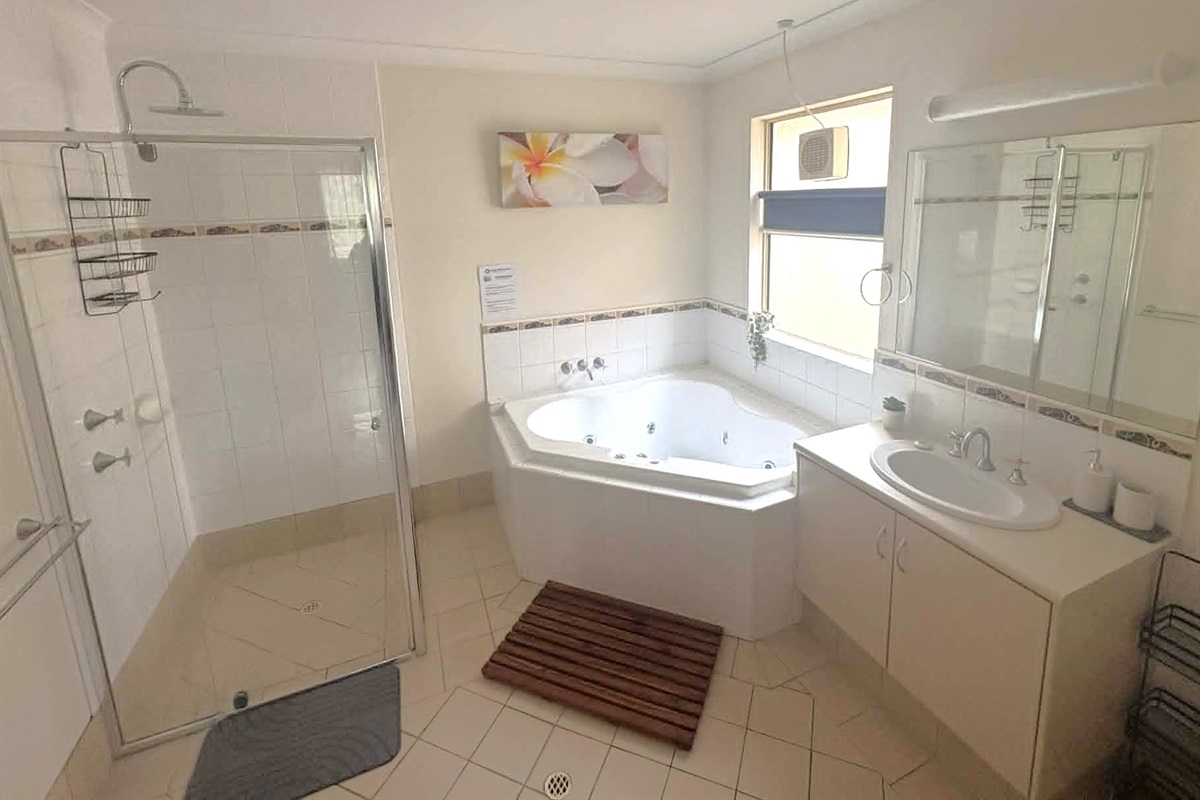 Ensuite / laundry combo features spa bath, washing machine & clothes dryer