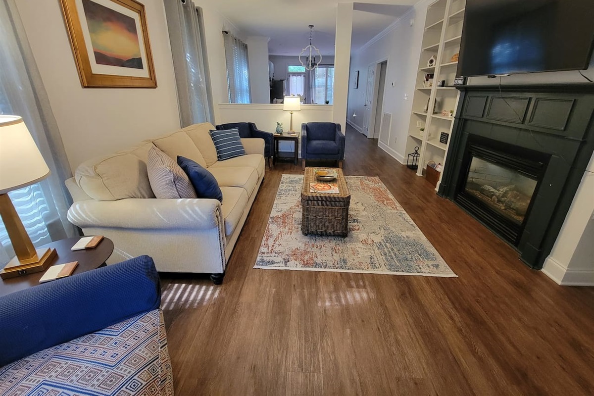 Well appointed living with comfortable study furniture, gas fireplace, and large TV.   Open to dining area and kitchen.