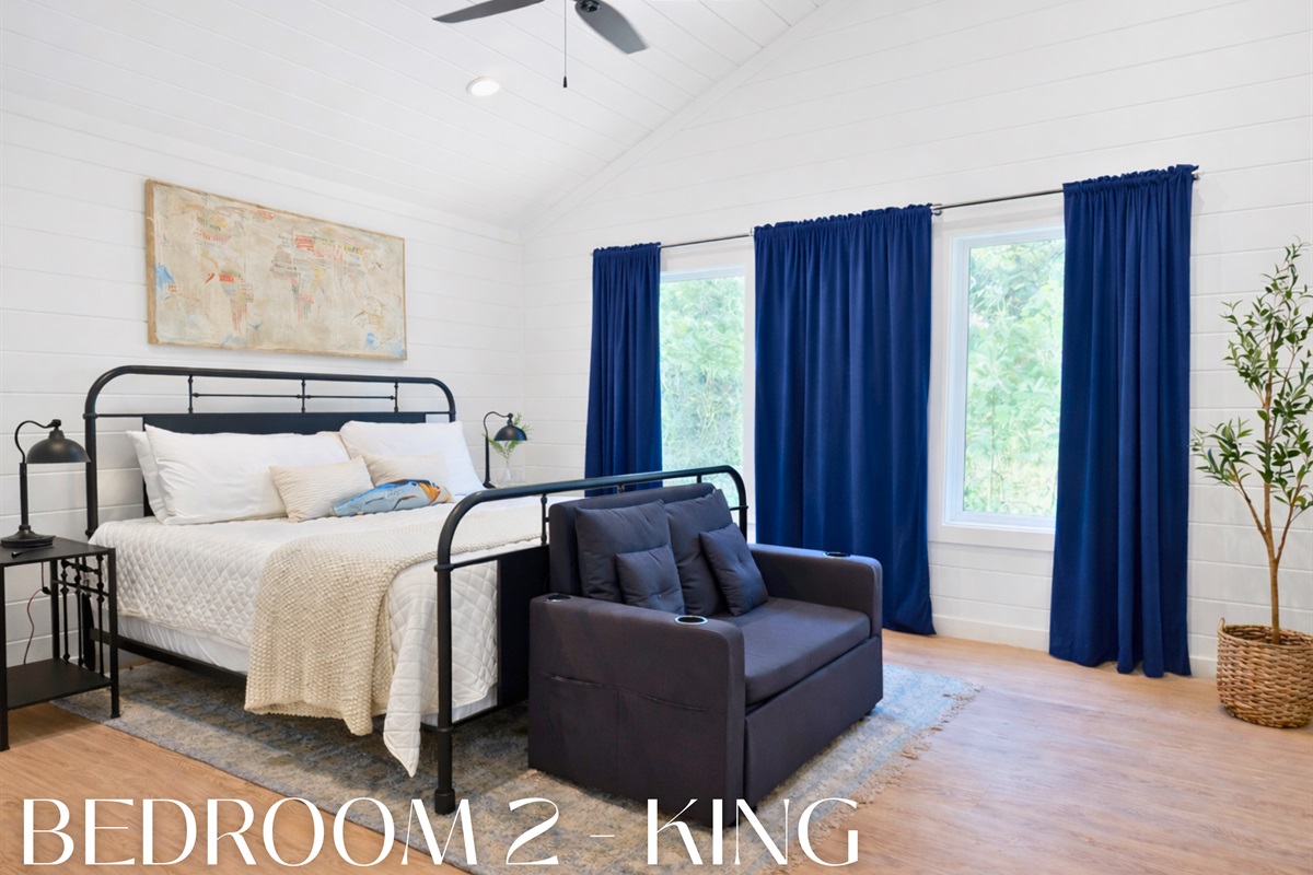 Bedroom 2 with king bed and forest views.