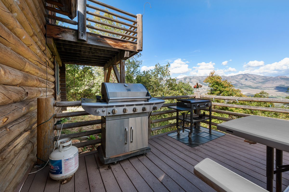 Outdoor grilling area on the wraparound deck with sweeping mountain scenery.