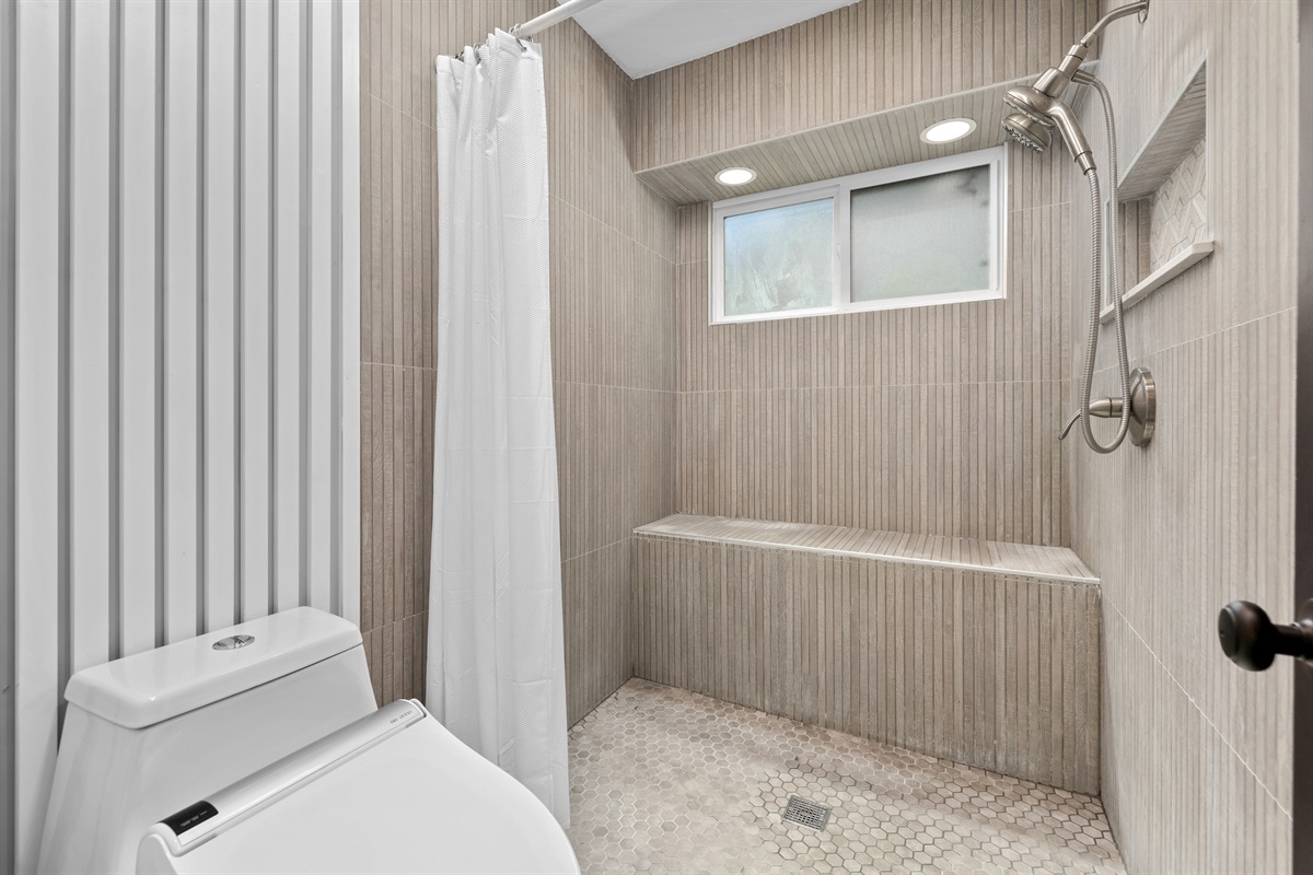 The primary ensuite bathroom is a luxurious space, featuring a g