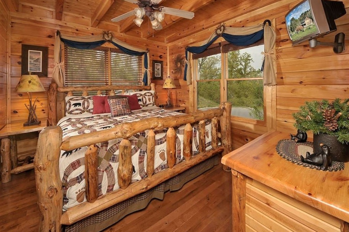 - Rustic log bedroom featuring handcrafted wood furniture and soft decor   - Cozy retreat with plush bedding and a flat-screen TV for easy relaxation   - Surrounded by natural light and forest views for a serene cabin escape