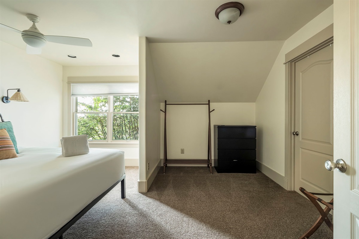 A dedicated dressing area with a clothes rack and dresser.