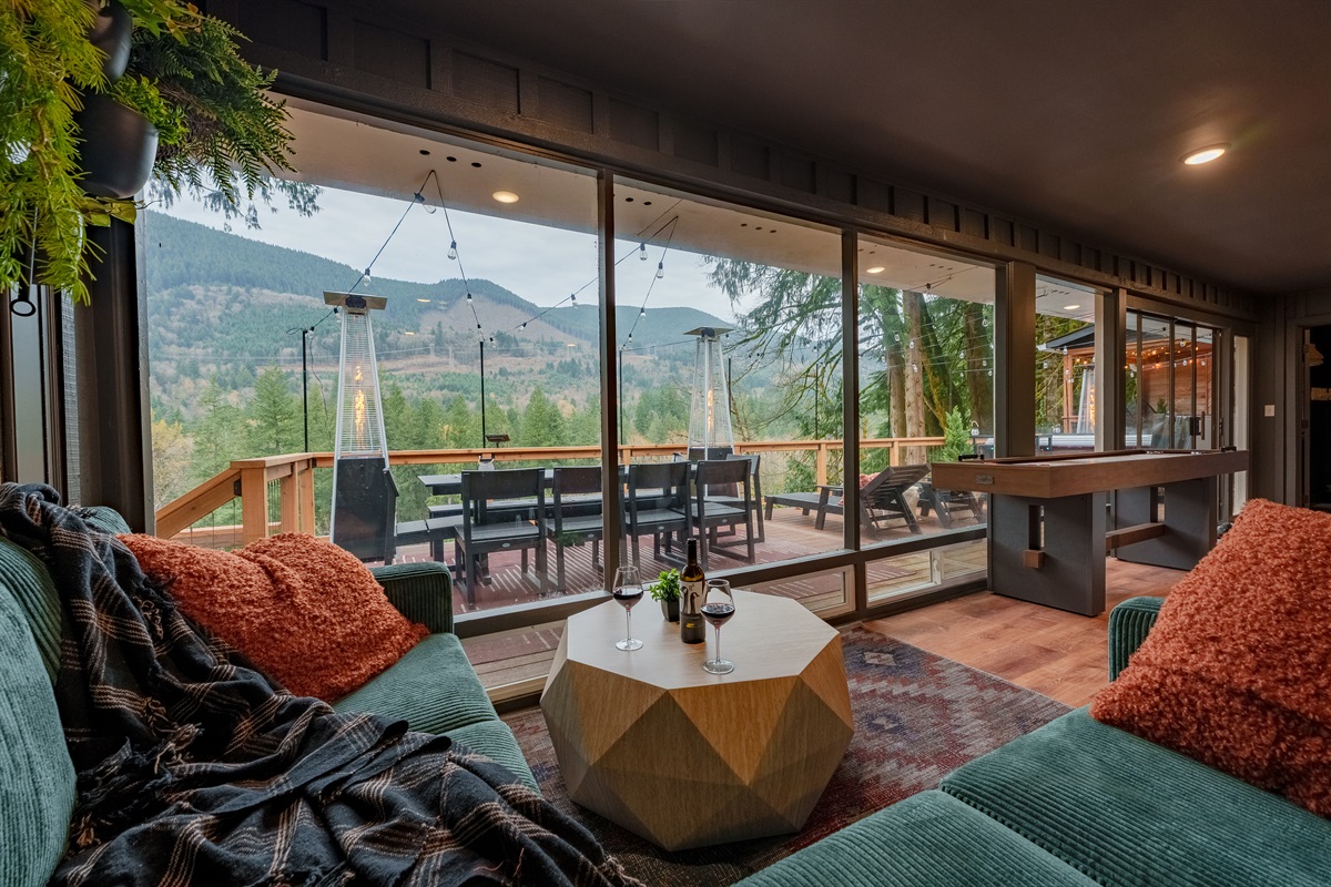 Take in sweeping forest and mountain views from the sun room, where soft seating, huge windows, and shuffleboard create a warm, inviting space for morning coffee or evening cocktails.