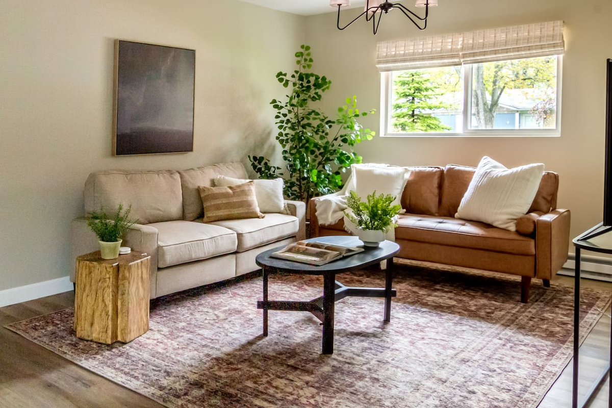 Warm leather and linen seating come together under a statement chandelier for a relaxed living room feel.