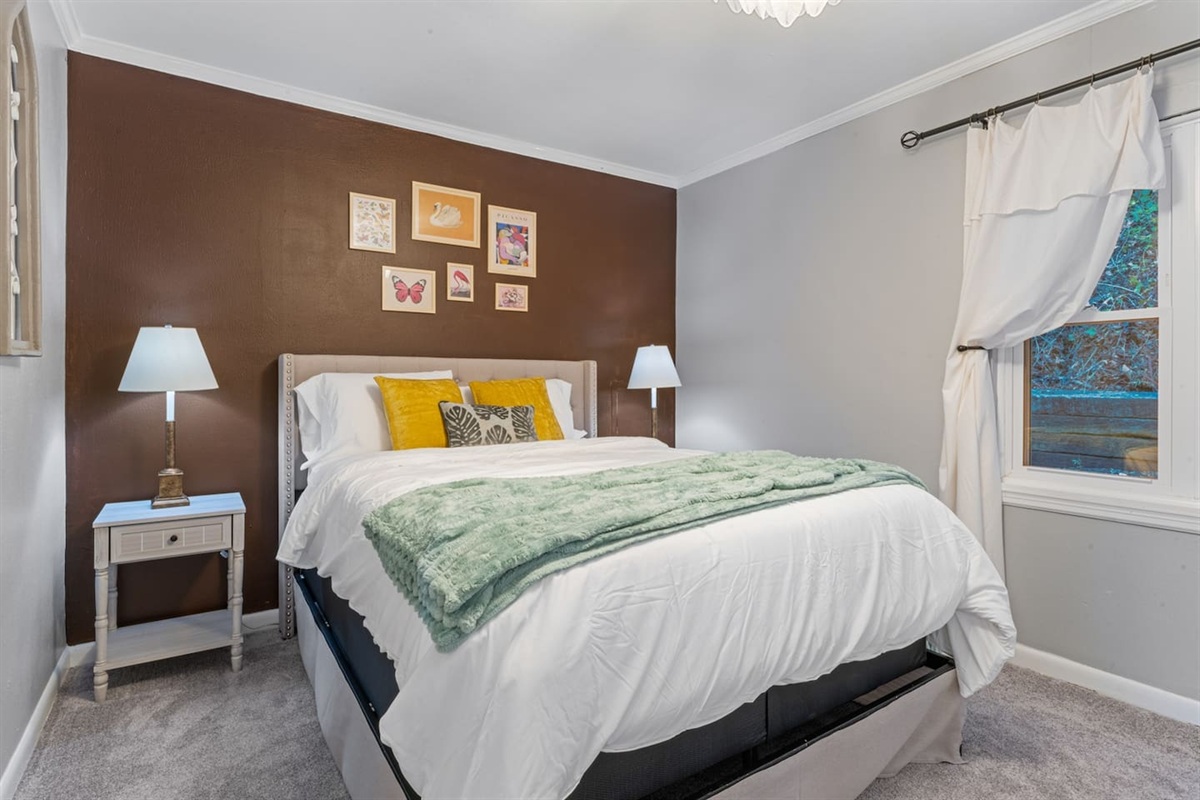 Relax in this serene bedroom with a cozy queen bed, modern décor, and your own TV for unwinding at the end of the day.