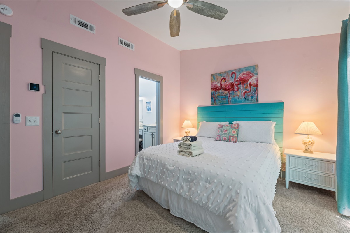 Third-floor master bedroom with Queen-size bed, ensuite bath access, and playful coastal accents&mdash;an inviting retreat with added privacy at the top level