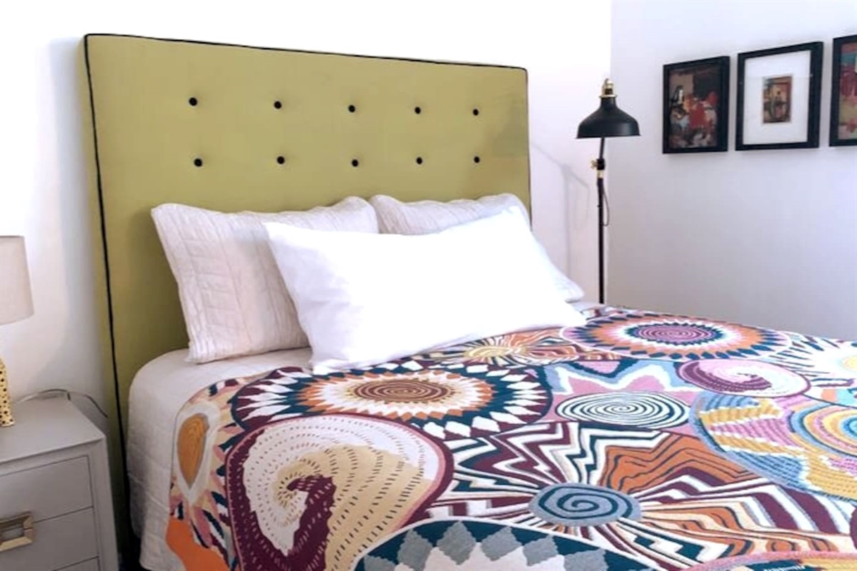 
Queen bed with luxury cotton linens, plush mattress, blackout shades, bedside table, soft lighting, ceiling fan & wireless charging station — our quietest room for deep, restful sleep