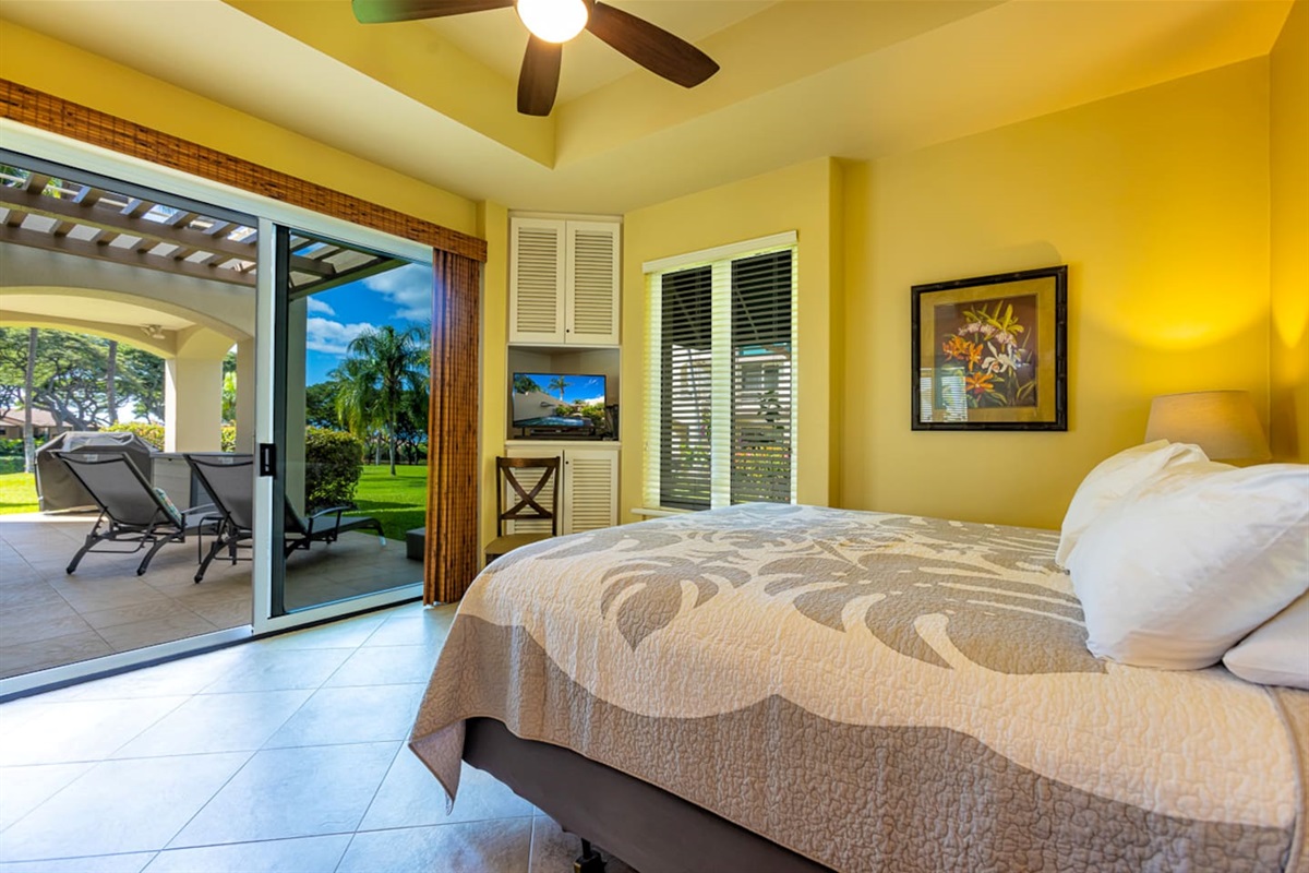 The main bedroom has a sliding door onto the large wrap-around lanai (two chaise-lounges just outside)